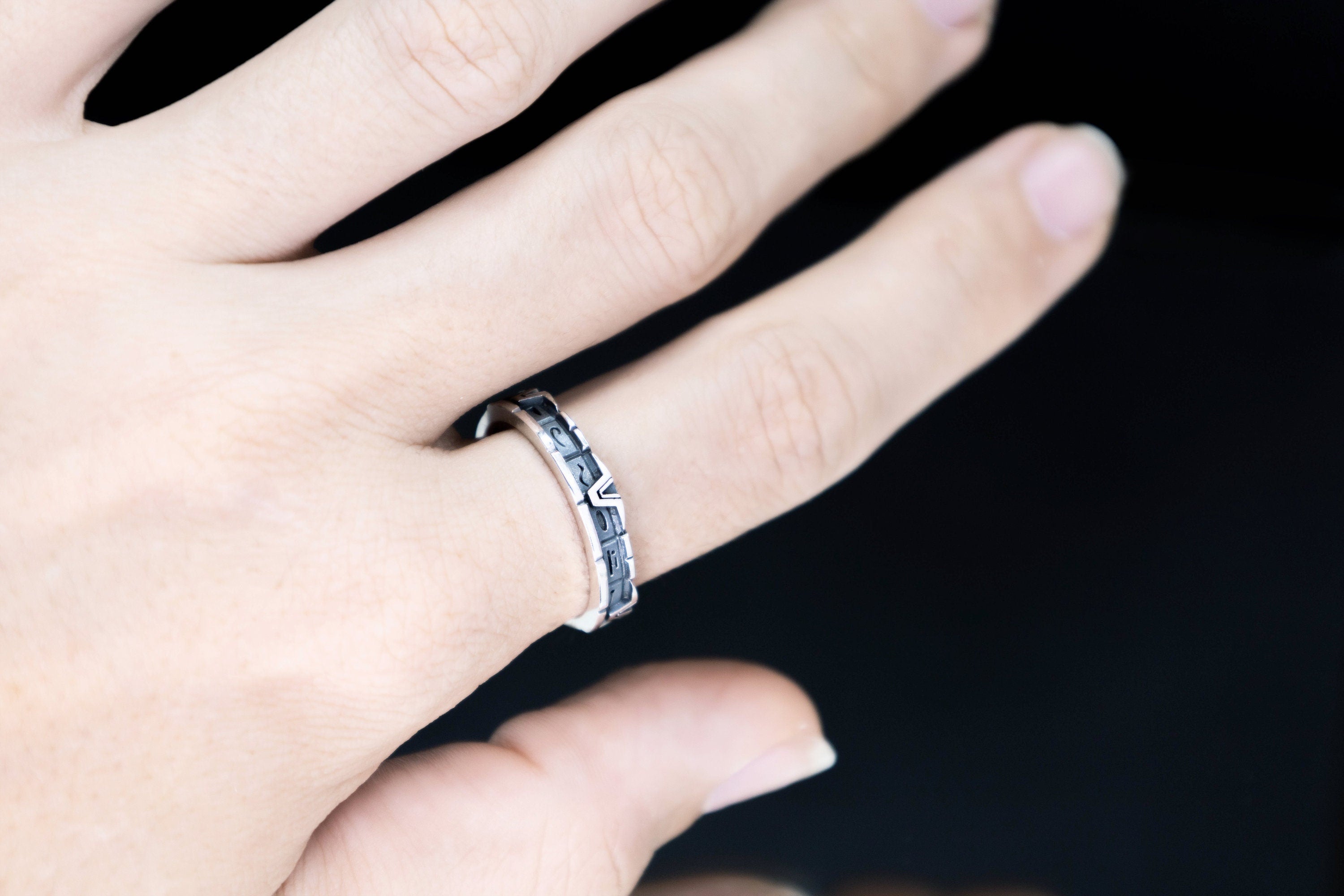 Unisex silver portal glyph band worn on hand