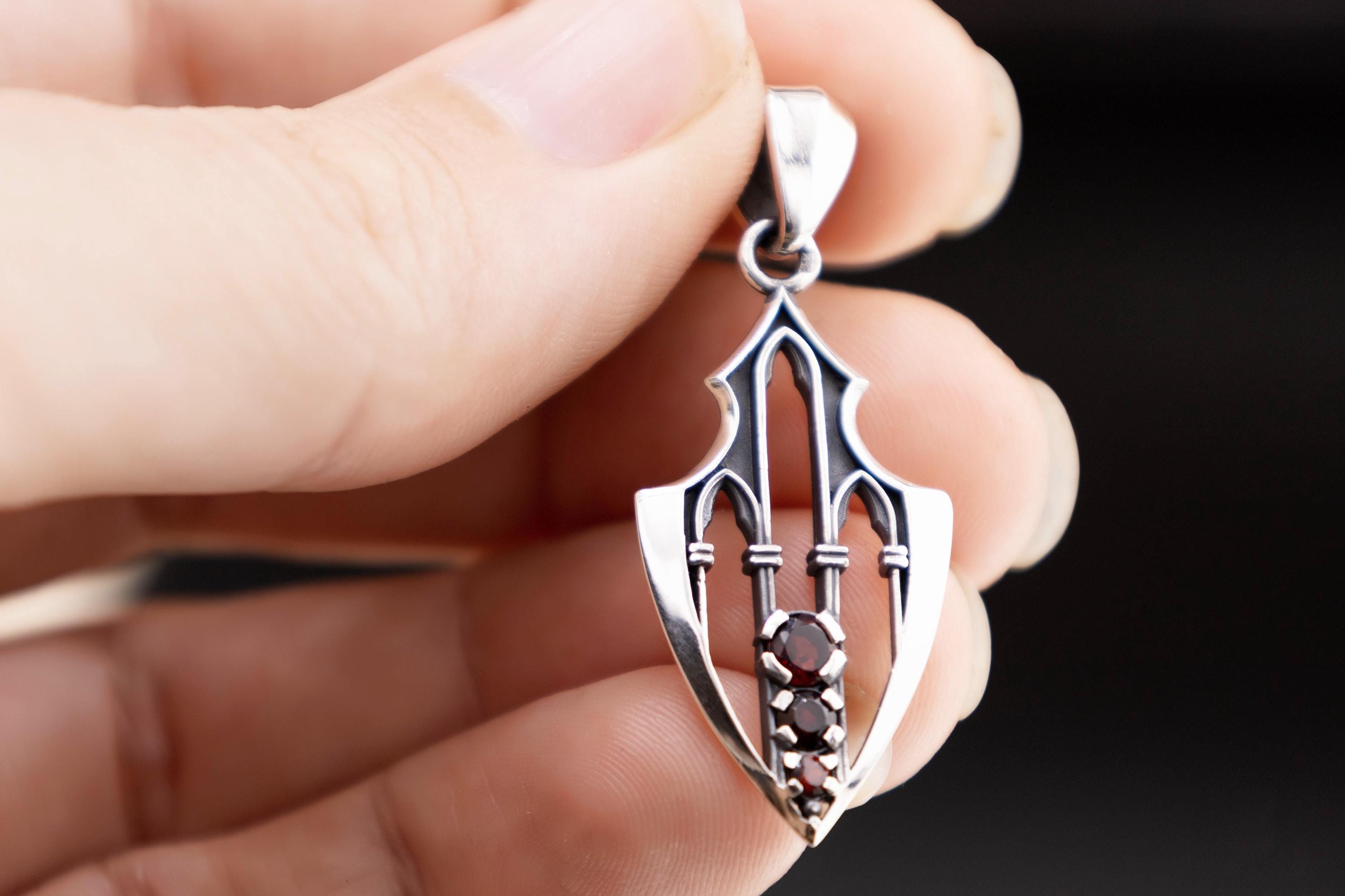 Close-up of gothic arrowhead necklace with natural garnets
