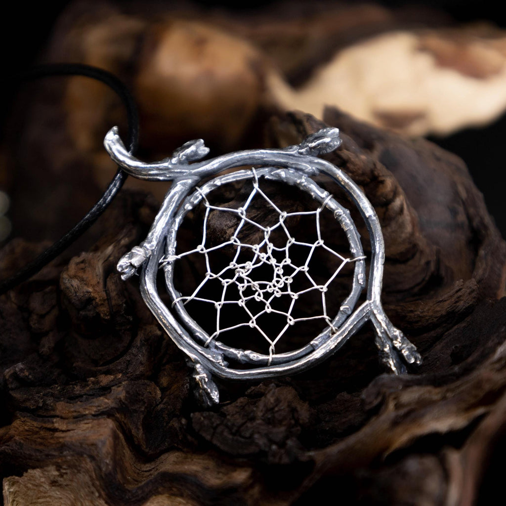 Sterling silver dreamcatcher pendant with branch frame on natural woodland background