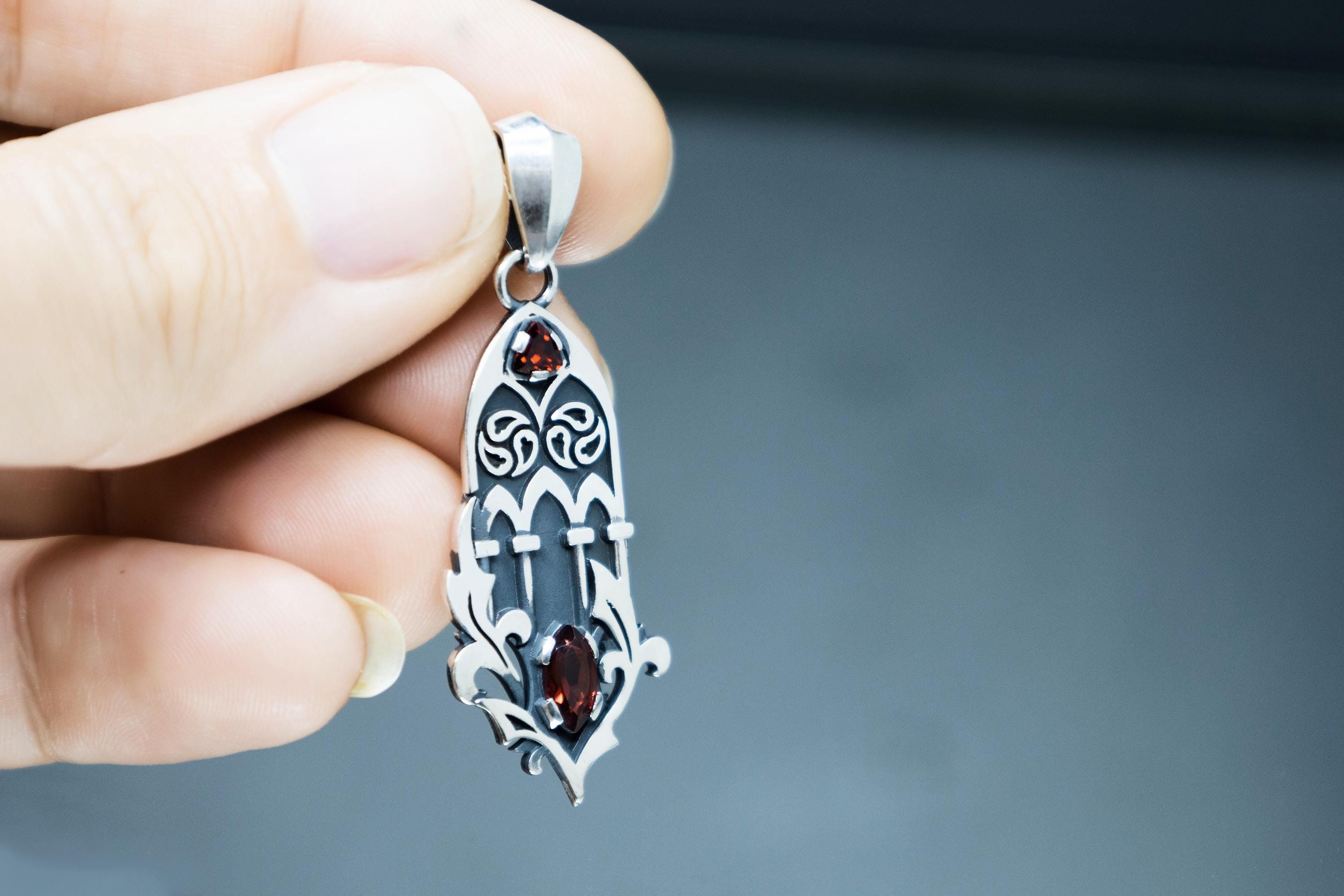 Openwork cathedral inspired silver pendant with garnet